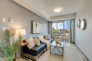 Waterloo apartment for rent - A living room with a black couch and a large window.