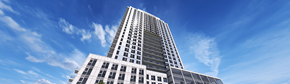 Waterloo apartment for rent - A tall building with many windows stands under a blue sky.
