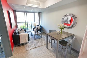 Waterloo apartment for rent - A living room with a couch, chairs, and a table with a vase of flowers on it.