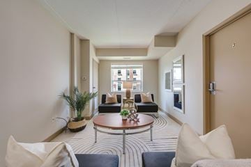 Waterloo apartment for rent - A living room with a striped carpet and a round coffee table.