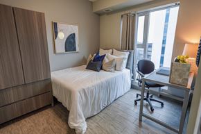 Waterloo apartment for rent - a bedroom with a bed and a desk and a window