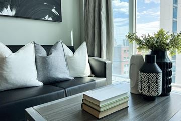 Waterloo apartment for rent - a living room with a couch and a table with books and a vase