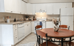 Waterloo apartment for rent - A kitchen with white cabinets and a wooden table.