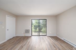 New York Mills apartment for rent - A room with wooden floors and a sliding glass door leading to a backyard.