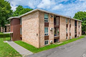 New York Mills apartment for rent - A brick apartment building with a green lawn in front.