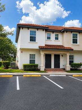 Bonita Springs apartment for rent - A white house with a red tile roof and a black front door.