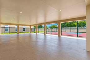 Miami apartment for rent - A spacious indoor area with a tennis court visible through the windows.