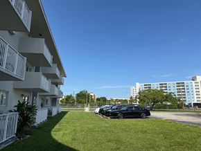 Cutler Bay apartment for rent - A black car is parked in a parking lot in front of a white building.