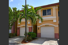 Davie apartment for rent - a house with two garage doors and a palm tree in front of it