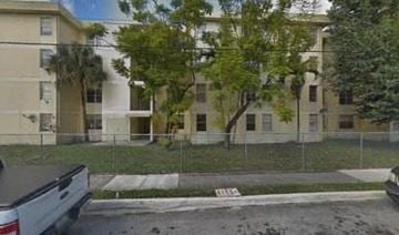 Hialeah apartment for rent - a view of an apartment building from behind a fence