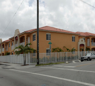 Hialeah apartment for rent - a large building with a fence in front of a street