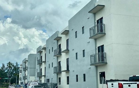 Hialeah apartment for rent - a white building with balconies and cars parked in front of it