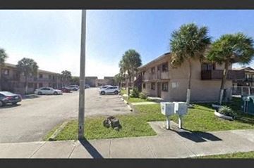 Hialeah apartment for rent - a street with cars parked in front of houses
