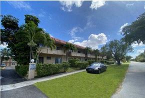 Miami Springs apartment for rent - a car parked in the grass outside an apartment building