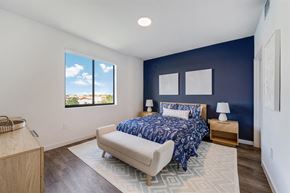 Miami apartment for rent - A bedroom with a bed and a blue wall and a window