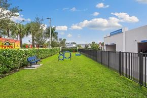 Miami apartment for rent - A grassy park with benches and a fence