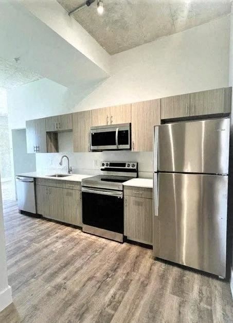 Miami apartment for rent - a kitchen with stainless steel appliances and a wooden floor