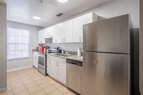 New Port Richey apartment for rent - a kitchen with stainless steel appliances and white cabinets