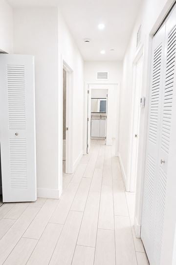 Hialeah apartment for rent - A white kitchen with a refrigerator on the left and a white cabinet on the right.