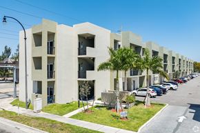 Hialeah apartment for rent - A row of modern apartment buildings with cars parked in front.