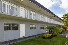 Boca Raton apartment for rent - A white building with a balcony and a white door.