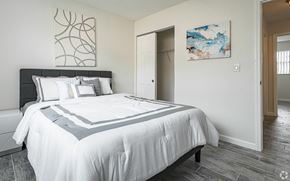 Boca Raton apartment for rent - A bedroom with a large bed and a painting on the wall.