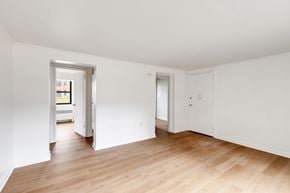 Albany apartment for rent - A room with white walls and wooden flooring with two doors.