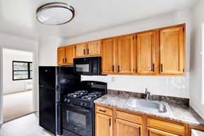 Albany apartment for rent - A kitchen with wooden cabinets and black appliances.