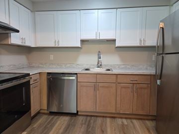Baldwinsville apartment for rent - A kitchen with wooden cabinets and a stainless steel dishwasher.