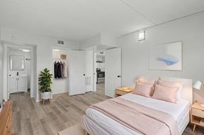 Merritt Island apartment for rent - A bedroom with a bed, nightstand, and a plant.