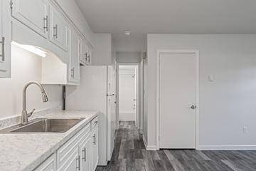 Staunton apartment for rent - A kitchen with white cabinets and a marble countertop.