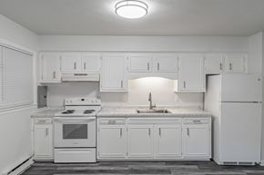 Staunton apartment for rent - A white kitchen with a stove, sink, and cabinets.