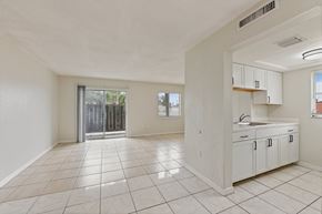 Fort Myers apartment for rent - A spacious, empty room with white cabinets and a tiled floor.
