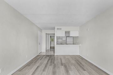 Fort Myers apartment for rent - A kitchen with white cabinets and a wooden floor.