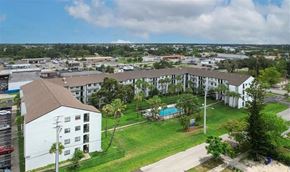 Fort Myers apartment for rent - A view of a residential area with apartment buildings and a swimming pool.