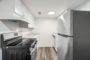 Staunton apartment for rent - A kitchen with a black stove top oven and a silver refrigerator.