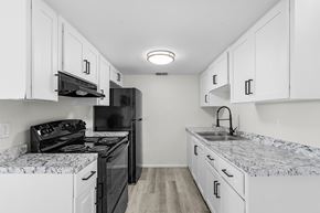Fort Myers apartment for rent - A kitchen with black appliances and white cabinets.