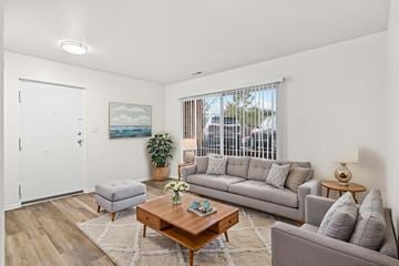 Staunton apartment for rent - A living room with a grey couch, a coffee table, and a painting on the wall.