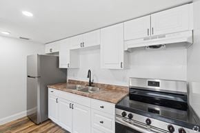 Merritt Island apartment for rent - A kitchen with white cabinets and a stainless steel refrigerator.
