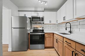 Albany apartment for rent - A modern kitchen with a stainless steel refrigerator, microwave, oven, and sink.