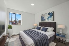 Albany apartment for rent - A bedroom with a large bed and a window overlooking a residential area.