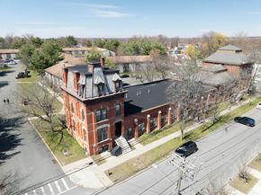 Albany apartment for rent - A large red brick building with a black roof and a tower with a dome on top.