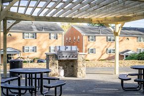 Waynesboro apartment for rent - A patio with tables and a fireplace in front of a brick building.