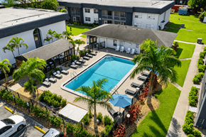 Fort Myers apartment for rent - A pool surrounded by palm trees and lounge chairs.