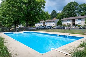 Staunton apartment for rent - A swimming pool surrounded by trees and apartment buildings.