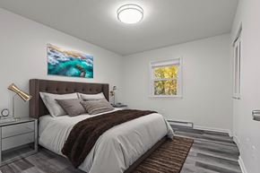 Staunton apartment for rent - A bedroom with a large bed and a painting of a beach scene on the wall.