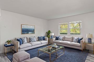 Staunton apartment for rent - A living room with a large couch, a coffee table, and a painting on the wall.