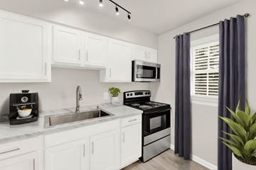 Verona apartment for rent - a kitchen with white cabinetry and black appliances and a sink