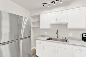 Verona apartment for rent - A modern kitchen with a stainless steel refrigerator and white cabinets.