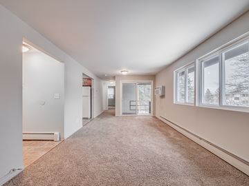 Baldwinsville apartment for rent - A spacious room with a carpeted floor and large windows.